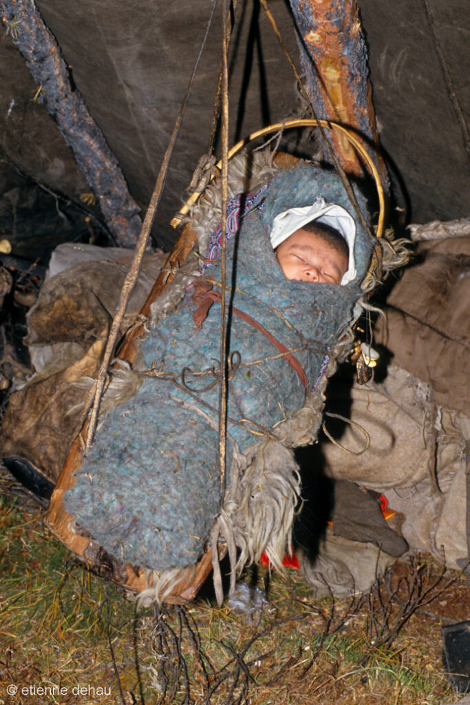 les nomades Tsaatan emmitouflent leur bébé dans de la laine de feutre, puis le posent sur une planche fixée à la structure de l'urt.