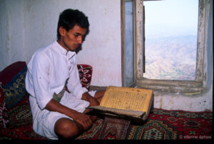 homme en train de lire le Coran au dernier étage d'une maison du village d'Al Hajjarein, dans le wadi Do'an.