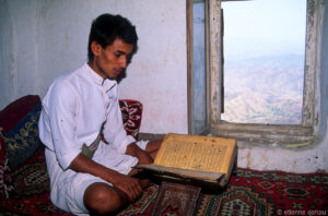 homme en train de lire le Coran au dernier étage d'une maison du village d'Al Hajjarein, dans le wadi Do'an.