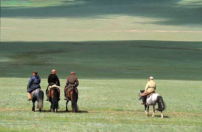 cavaliers kazakh chevauchant dans la steppe à l'ouest de la Mongolie