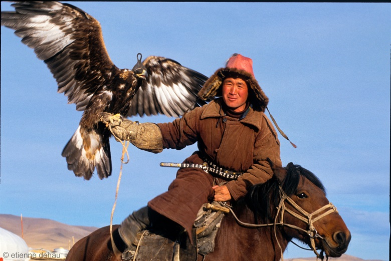 eagle-horse-mongolia Kazakh nomad on horseback going hunting with his eagle, in western Mongolia